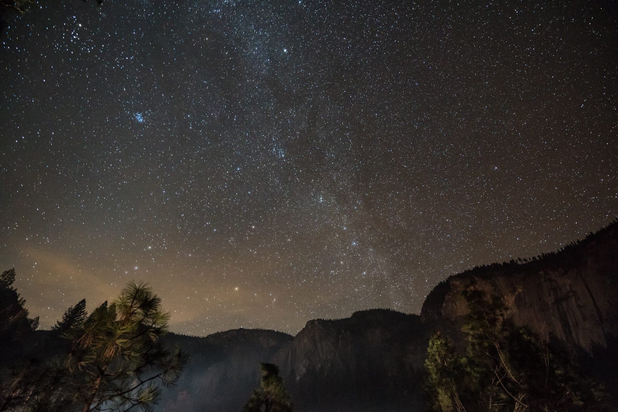 The Milky Way over the silhouetted cliffs of Yosemite at night