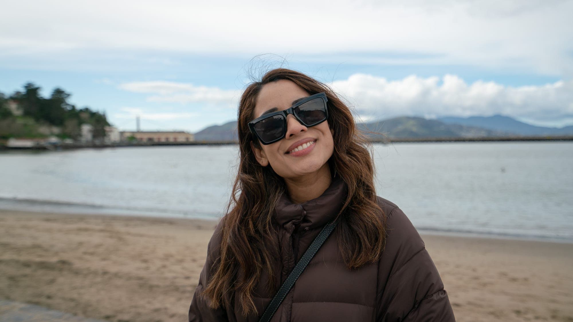 Candid beach portrait with the Golden Gate Bridge faint in the distance