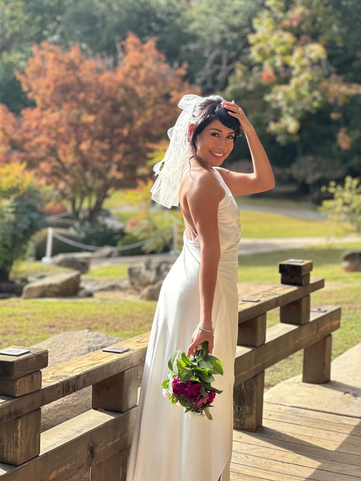 Bride in the Shinzen Japanese Garden holding her bouquet under autumn trees