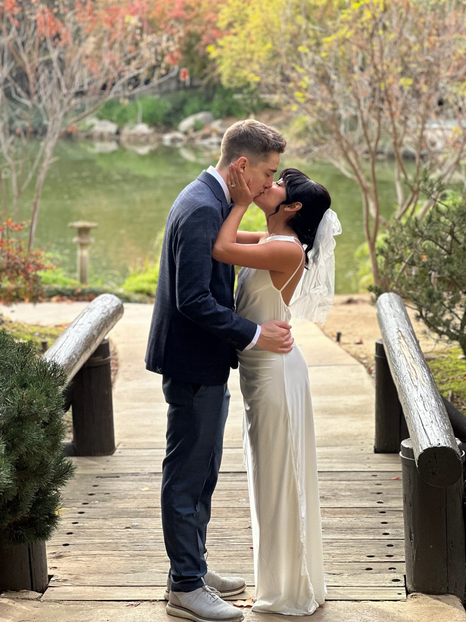 Couple kissing on a wooden bridge at their Japanese garden elopement